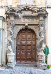 Ornate wooden door with carved stone columns and green flag