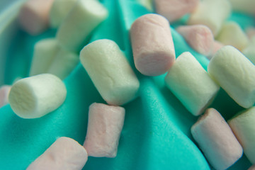 Close up of delicious pink and white marshmallows on top of blue ice-cream