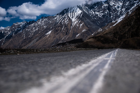 Endless Road Close Up With Snowy Mountains In The Background 