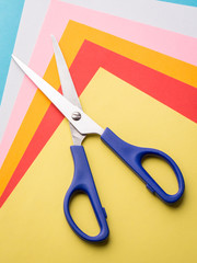Photo of a scissors and different colorful papers. Concept of origami making
