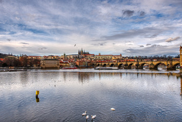 historical part of prague with castle and cathedral and charles bridge beautifully lit by sunset,...