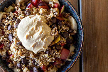 Fruit salad with slices of banana, blackberries, watermelon, peaches and nuts, yogurt sauce