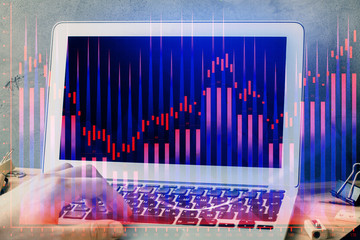 Forex graph with businessman working on laptop on background. Concept of hardworking. Multi exposure.