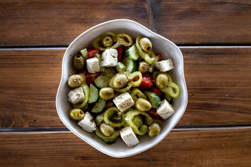 Greek salad with tomatoes, cucumbers, green and red bell peppers, green olives and feta cheese, olive oil