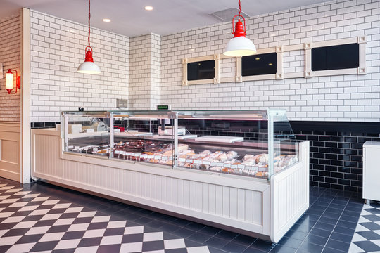 Interior display showcase of a delicatessen shop with cheese, sausages and dairy products