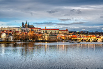 Fototapeta na wymiar historical part of prague with castle and cathedral and charles bridge beautifully lit by sunset, czech prague