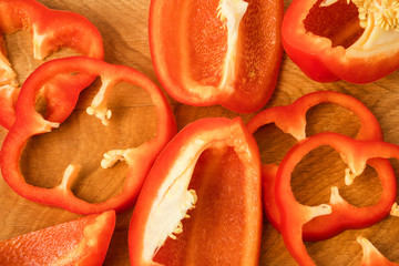 red bell pepper cut into pieces on a wooden board