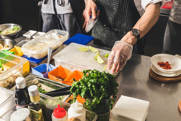 Professional chef cooking in the kitchen restaurant at the hotel, preparing dinner. A cook in an apron makes a salad of vegetables and pizza.