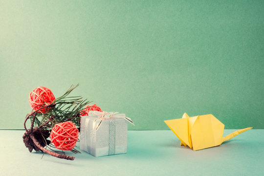 chinese new year concept. Origami white paper mouse looks gift. next to the gift lies a pine branch with orange balls..