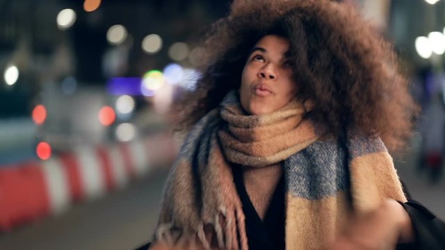 Happy afro american woman having fun and dancing at the evening street. Slowmotion.