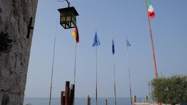 Flags on Blue Sky. Garda Lake, Italy. Lasize pier area