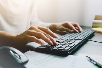 2 hands of Asian woman is press, typing on 2 language keyboard as Thai and English. Maybe preparation about information to report, chat to lover or shopping online by connect to internet at home, cafe