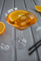 Aperol spritz cocktail in martini glass on the grey wooden background.  Location vertical. Copy space.