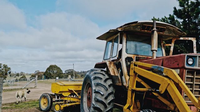 An old rusted International tractor slowly reverses into the fields of an Australian farm