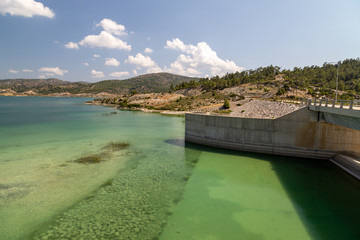 Fototapeta na wymiar Dam of the Gadoura water reservoir on Rhodes island, Greece with blue and turquoise water