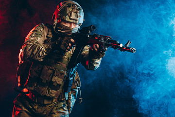 courageous soldier man in green military wear holding gun, rifle in hands, don't afraid of danger, looking for enemy