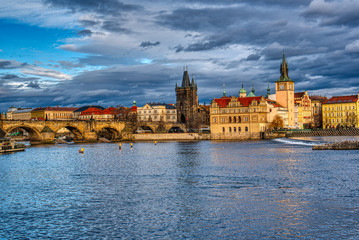 Obraz premium Beautifully illuminated Charles Bridge at sunset with surrounding buildings, Prague