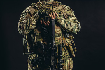defense and military forces concept. unrecognizable cropped soldier holding weapon in hands