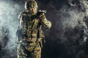 special forces soldier man holding machine gun and military equipment in smoky space