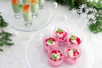 Fototapeta na wymiar Christmas appetizers, mousse with beetroot , avocado and spinach in glasses.