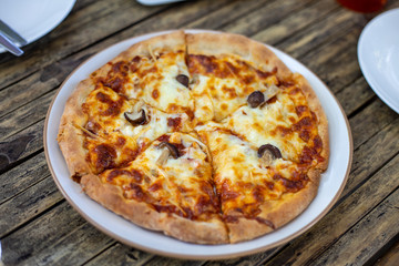 Slice of delicious pizza On a plate on a wooden table