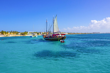 Tourists snorkeling along the coastline and enjoy the tropical island of Aruba