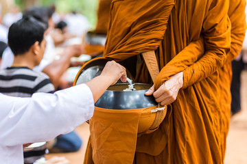 People offer food to the monks in the morning at temple.