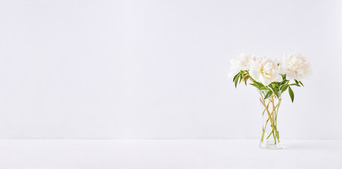 Home interior with decor elements. White peonies in a vase on a white background