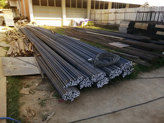 Deformed steel bars are stacked together on the construction site. Construction rebar steel work reinforcement in concrete structure of building.