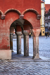 Stone columns of arcades of historic tenement houses on the market square in Poznan..