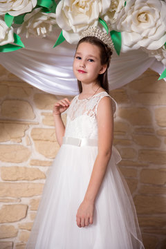 Portrait of bride with diamond diadem in hair on the background of flower arch