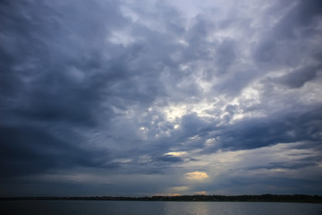 Fototapeta na wymiar sunset in the cloudy sky above the lake