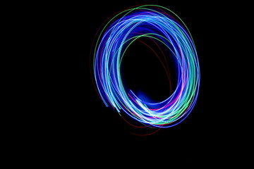 Long exposure photograph of a letter o in neon colour in an abstract swirl, parallel lines pattern...