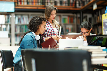 Group of female students study in the college library.Learning and preparing for exam.Educational...