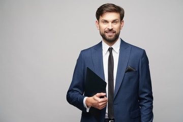 Portrait of a handsome young business man holding folder