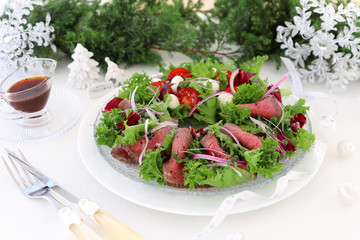 Holiday salad with roast beef on christmas decoration background