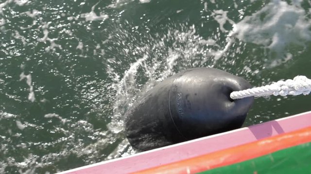 wood yacht boat rubber buoy fender floater while navigating slow motion