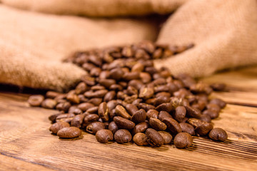 Sackcloth and scattered coffee beans on wooden table