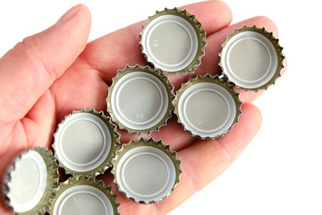 many soda bottle caps in the palm of a person,