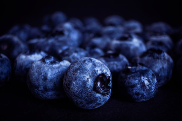 Blueberries close-up. Macro photo. The concept of organic food, vegetarianism, tasty and healthy berries. Dark tones.
