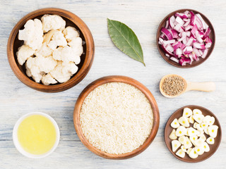Ingredients for cooking basmati rice: cauliflower, butter, red onion, bay leaves, garlic, cumin (jeera). Healthy eating concept