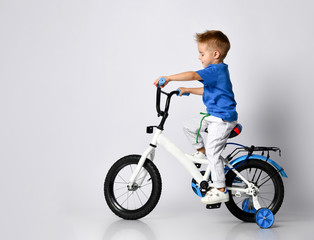 young boy happily riding on a bicycle on isolated background