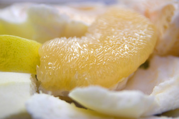 peeled pomelo fruit on a white plate close-up
