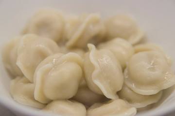 Boiled dumplings on a white plate close-up