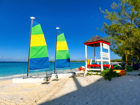 Colorful sailboats and motorboat, on a tropical beach at Half Moon Cay in the Bahamas