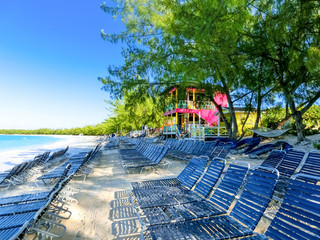 Colorful tropical cabanas or shelters on the beach of Half Moon Cay