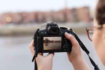 Young female photographer taking picture with camera