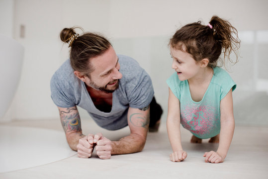 Kindercoach - Mann und M&auml;dchen machen gemeinsam Liegest&uuml;tz