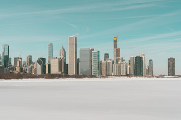 Chicago downtown panorama in winter, frozen lake, snow covers Lake Michigan. Tall skyscrapers under construction