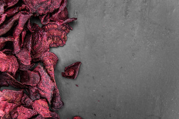 Portion of fresh made Beetroot Chips on a slate slab (selective focus)